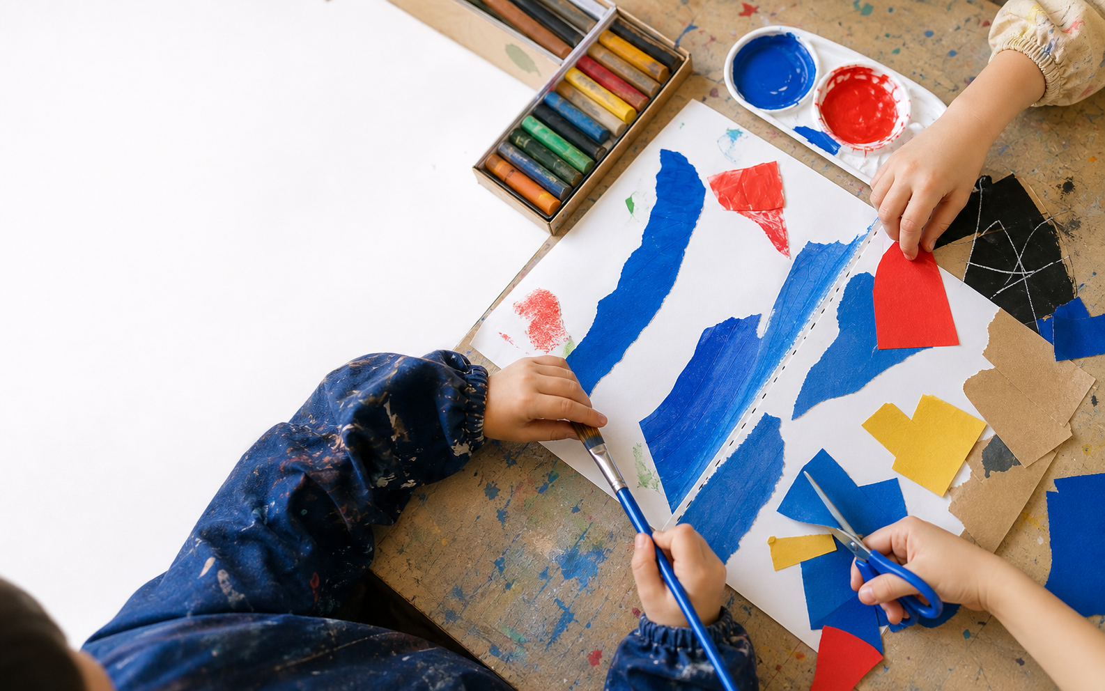 青、赤、黄色の紙と絵の具で作品をつくる子どもたちの手元